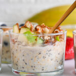 Apple cinnamon overnight oats topped with apple and almond butter, being served with a golden spoon