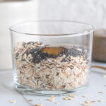 Old fashioned rolled oats, chia seeds and maple syrup in a glass, ready to add milk