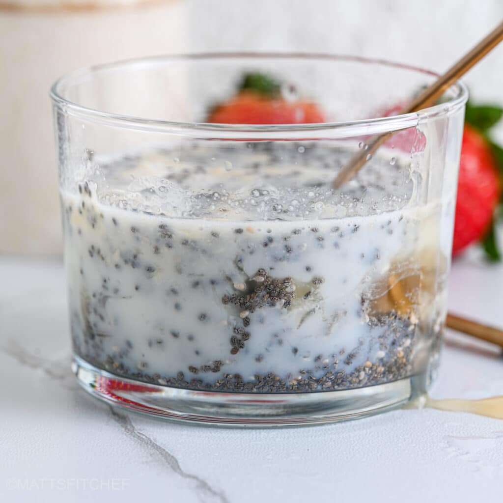 Stirring protein powder chia pudding with a golden spoon to break lumps.