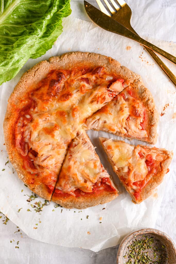 High protein pizza crust with shredded chicken cut into 3 slices.