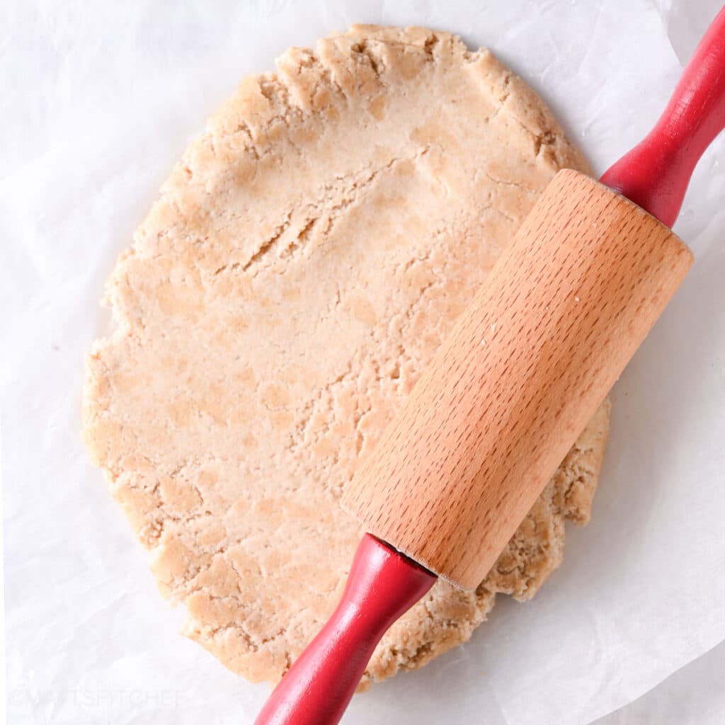 Rolling Greek yogurt protein dough into a circle with a rolling pin.