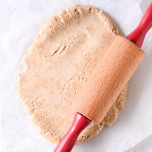 Rolling Greek yogurt protein dough into a circle with a rolling pin.