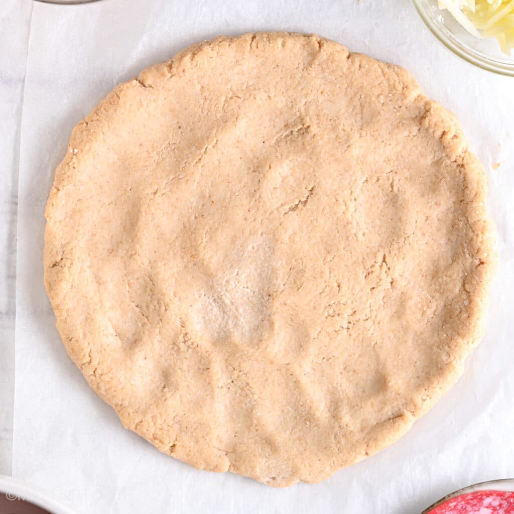 High protein pizza crust after rolling, ready to be topped with tomato sauce, cheese and meat