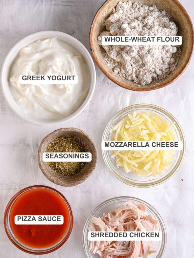 Homemade protein Pizza Ingredients - Wholewheat flour, Greek yogurt, seasonings, shredded mozzarella cheese, pizza sauce, shredded chicken