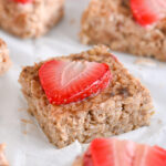 Strawberry Oatmeal Bars with No Sugar – Close-up of a strawberry oat square topped with a vibrant red slice of fresh strawberry.