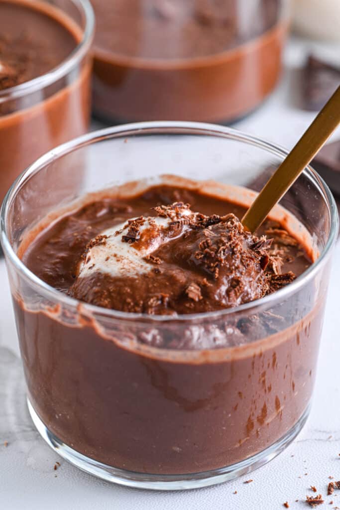 Close-up of sugar free chocolate pudding being served with a golden spoon &ndash; the creamy texture is highlighted