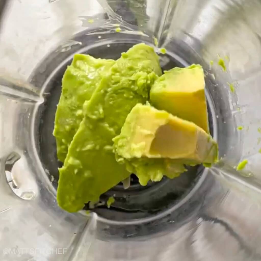 Diced avocados in a blender, ready to add cocoa powder and maple syrup before blending.