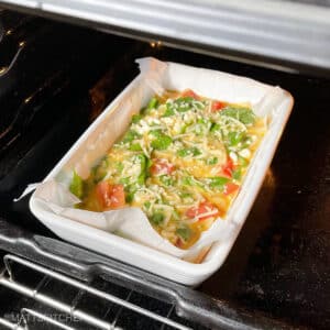 Cottage cheese eggs casserole in hot oven, before baking.