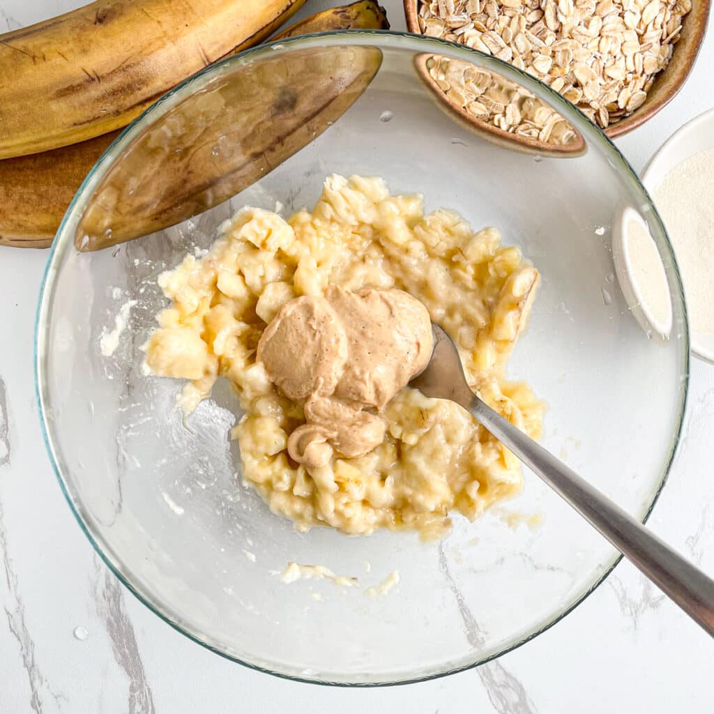Mashed banana with creamy peanut butter in a bowl, before mixing until smooth