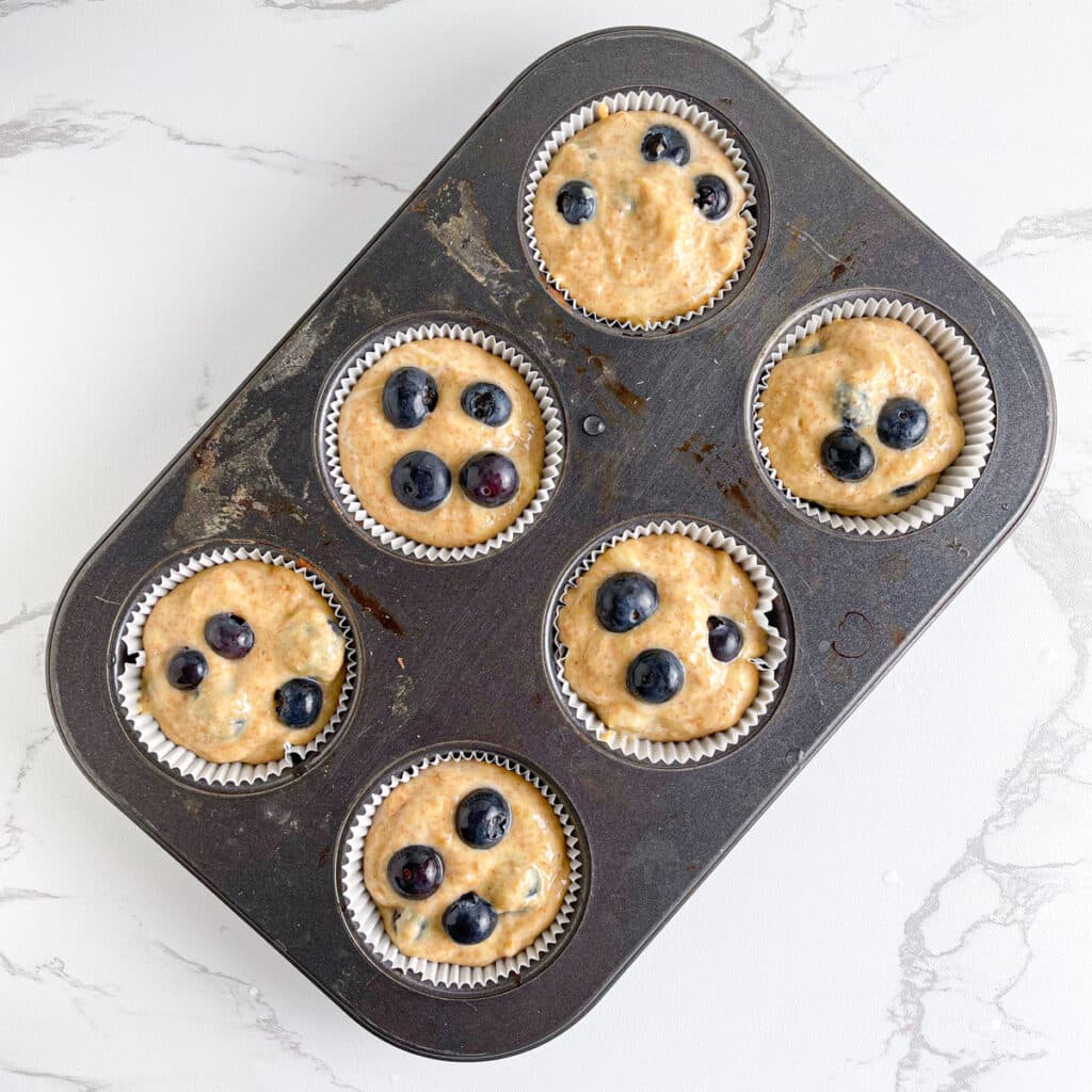 Cottage Cheese Blueberry Muffins in muffins tins ready to bake in the oven