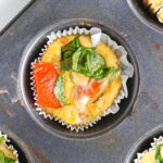 Close up of cottage cheese egg bites with chopped spinach and diced tomatoes one top