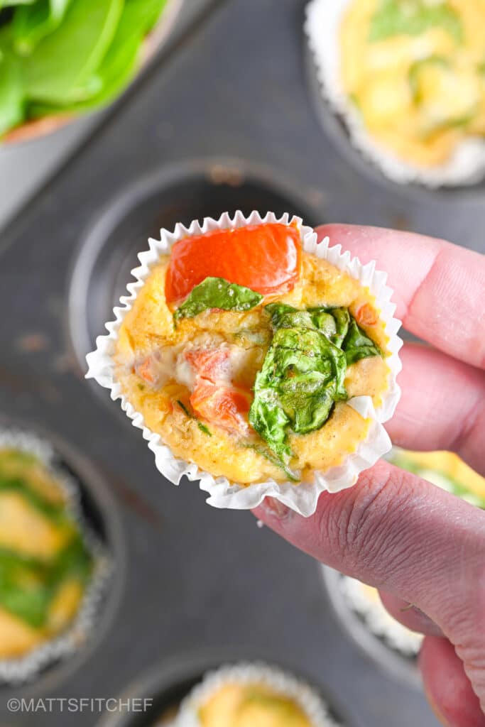 Holding a high protein egg bite with cottage cheese with the hands