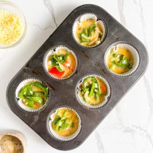 Cottage cheese egg bites in a muffin pan, ready to bake