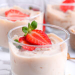 Blended overnight oats in glass jars, topped with strawberries