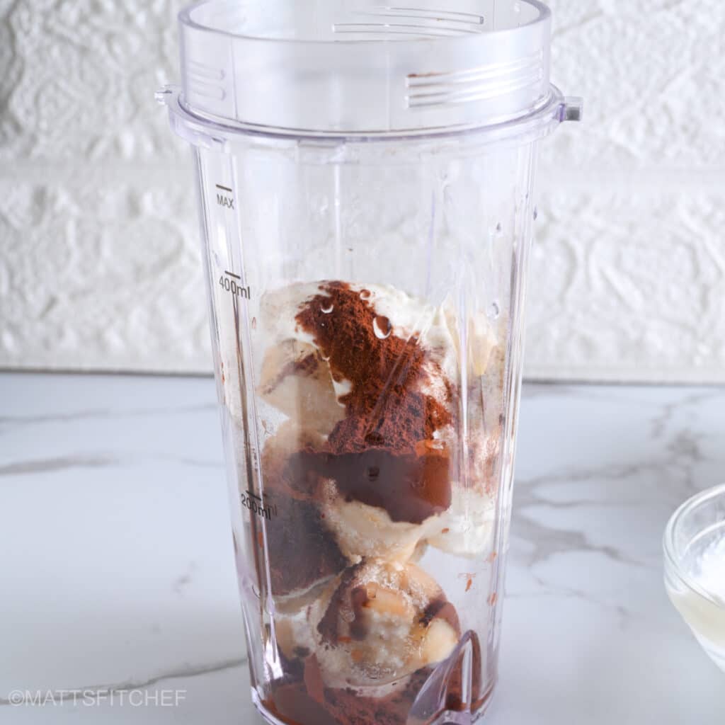 Adding optional cocoa powder to ingredients for chocolate protein ice cream.