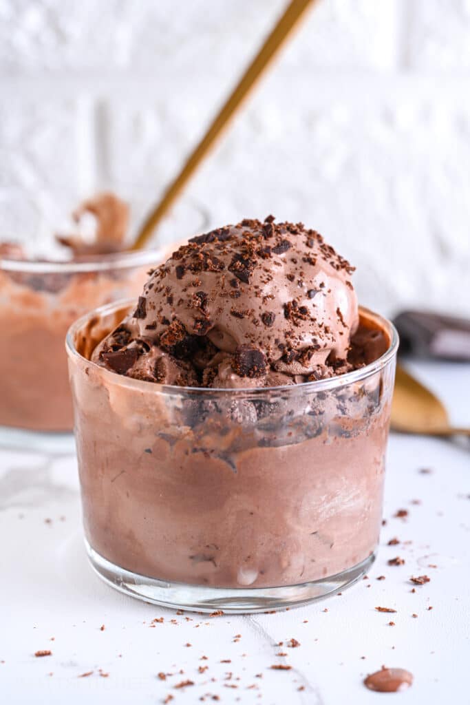 Creamy protein ice cream topped with dark chocolate shaves, featuring a rich and creamy texture similar to original gelato.