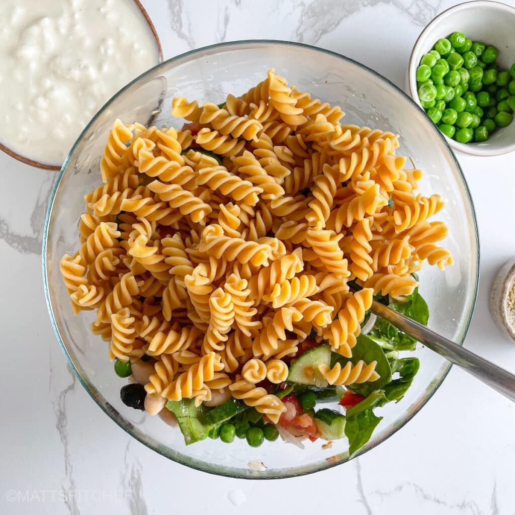 Cooked pasta added to the chopped vegetables, ready to add cottage cheese, dressing and toss