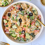 High Protein Pasta Salad in a plate, shown from the top. This cold summer dish is loaded with summer vegetables, protein-packed cottage cheese and beans, and a creamy dressing that is low calorie and high in vegetarian protein