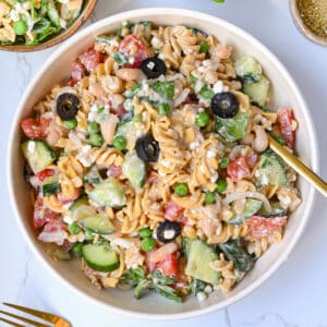 High Protein Pasta Salad in a plate, shown from the top. This cold summer dish is loaded with summer vegetables, protein-packed cottage cheese and beans, and a creamy dressing that is low calorie and high in vegetarian protein