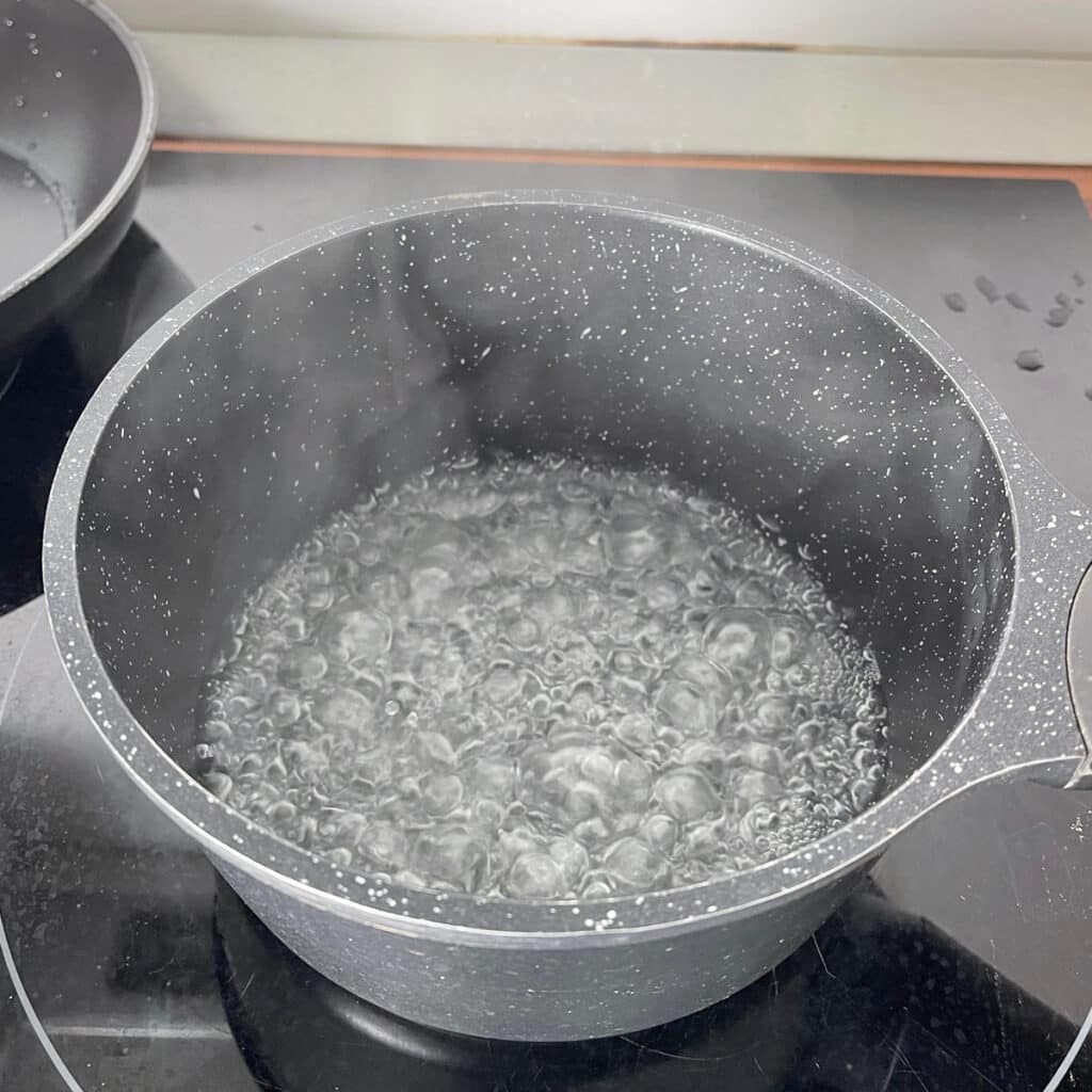 Boiling water in a black pot, time to add oats