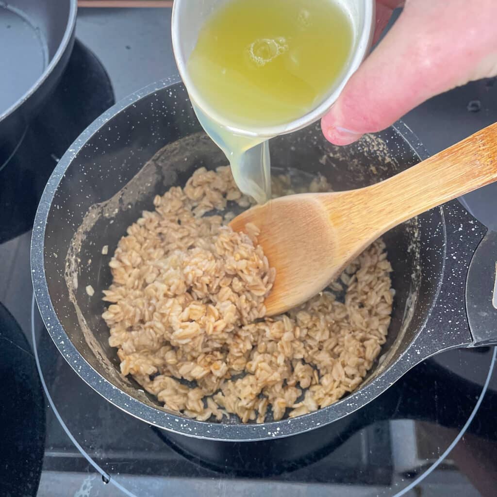 Adding liquid egg whites to cooked salty oats, ready to stir well