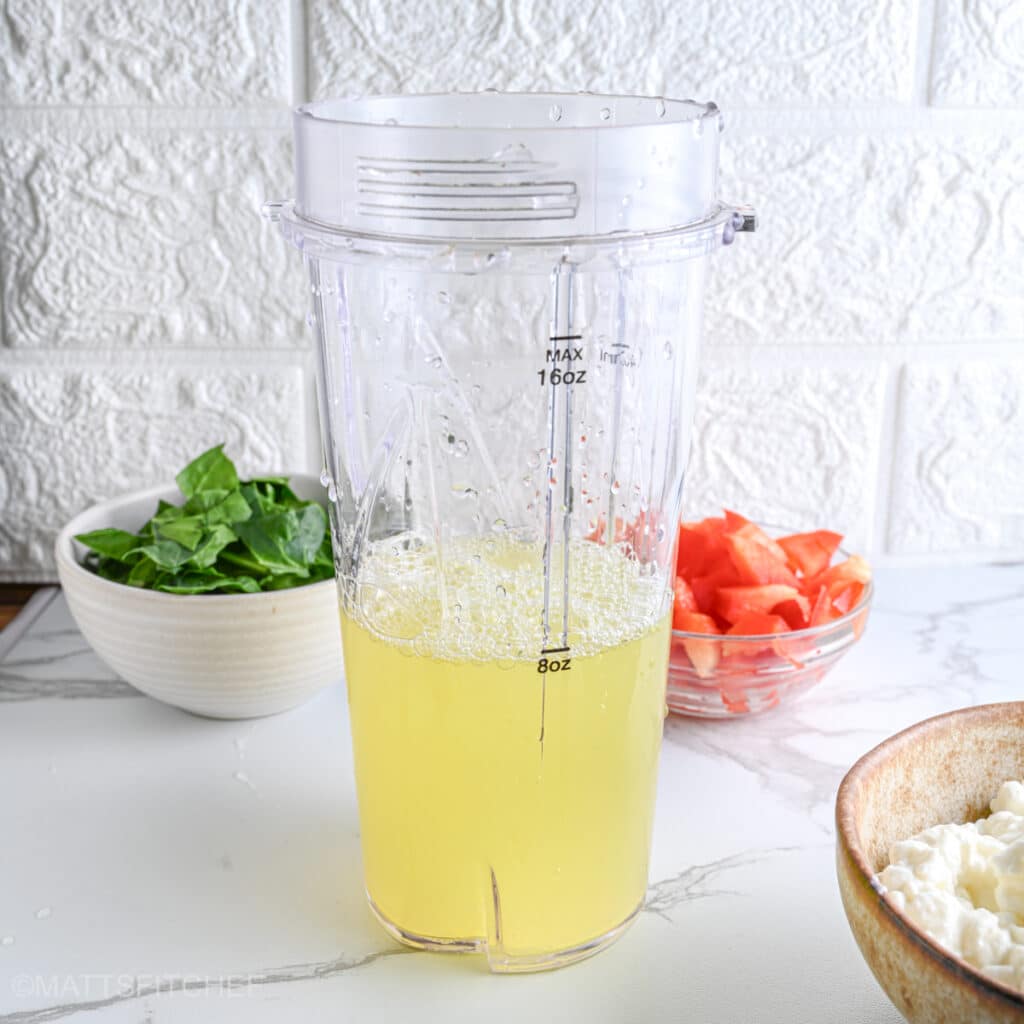 Liquid egg whites in a blender, ready to combine with creamy cottage cheese, mozzarella and seasonings