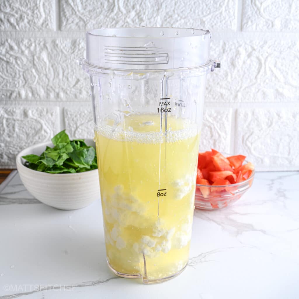 Liquid egg whites and creamy cottage cheese in a bullet blender, before mixing until smooth for protein bites