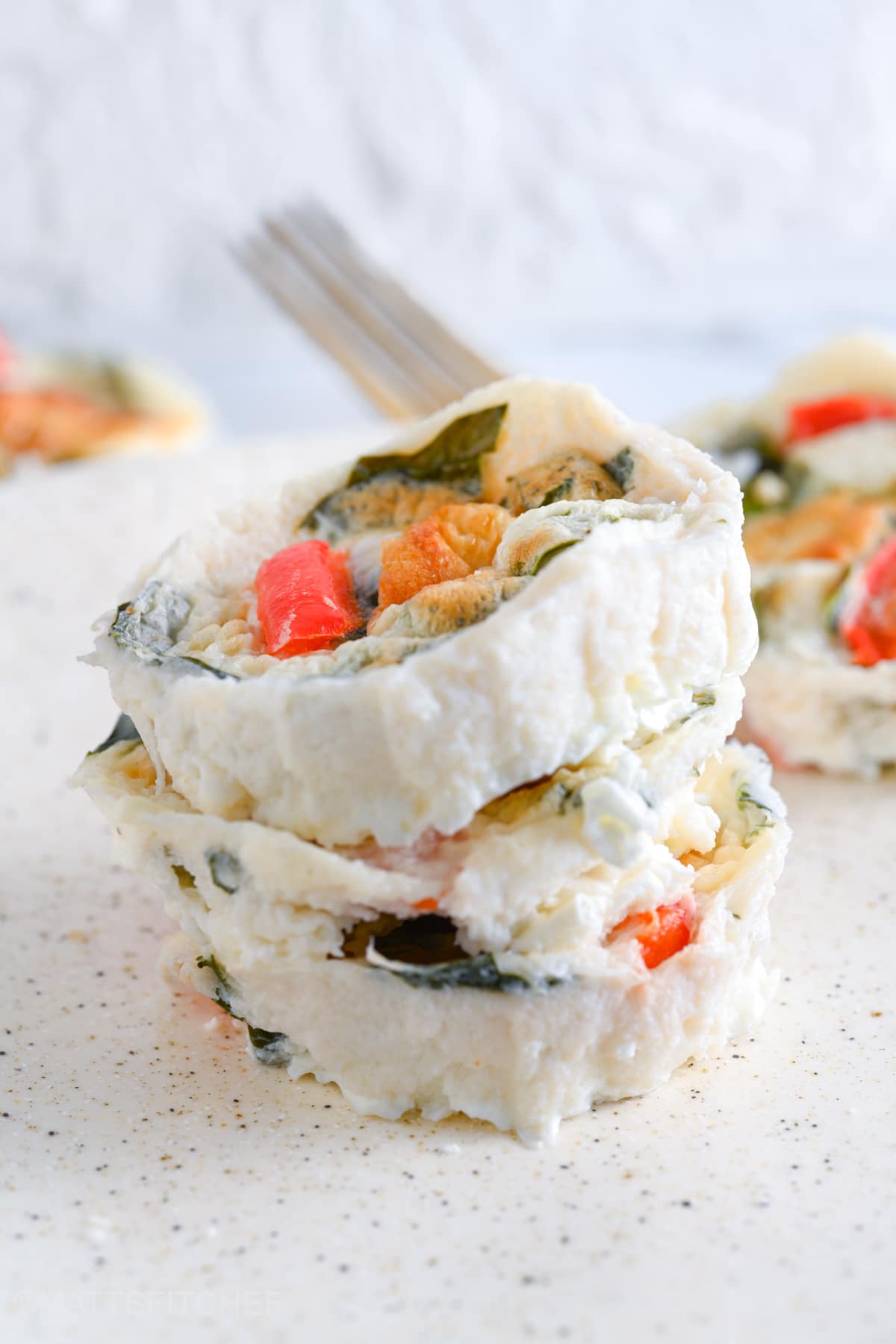 Cheesy and tender Starbucks egg white bites made at home, after baking. 3 egg white bites are piled, showcasing flavorful spinach and roasted bell peppers on top