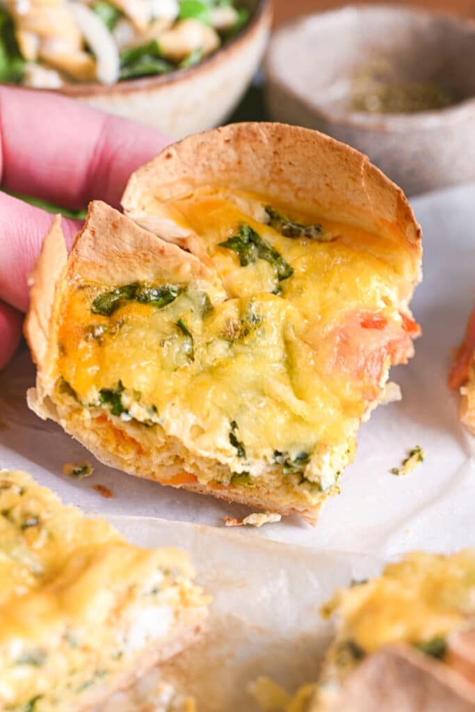 Left hand of Matteo, the chef, grabbing a slice of quiche made from tortilla wrap. Perfect as a complete breakfast, lunch or dinner.