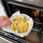 Placing tortilla quiche in the oven, to bake it until set.