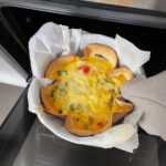 Baked tortilla quiche being removed from the oven. It features a golden cheesy topping and a crispy crust.