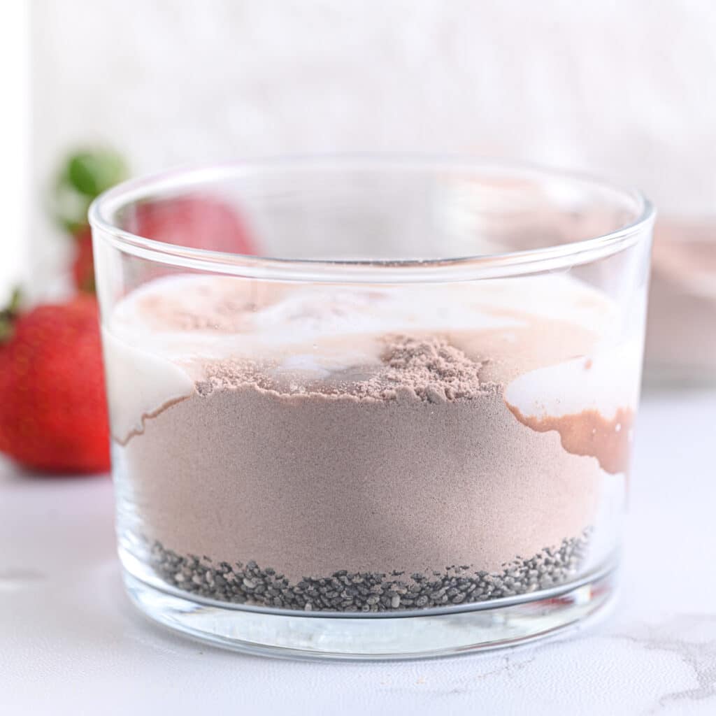 Milk added to cocoa powder and chia seeds, ready to mix