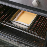 Pan with raw flatbread batter in oven, ready for baking