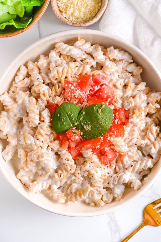 High protein pasta sauce with cottage cheese, topped with diced tomatoes and sprinkled Parmesan cheese