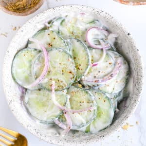 Creamy Greek yogurt cucumber salad with dill, seasonings and sliced red onion