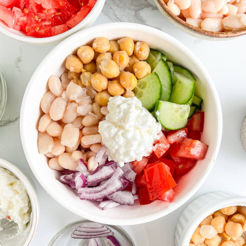 Mixed beans and vegetables in a bowl, ready to mix into a high protein salad