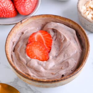 Greek yogurt and protein powder, smooth and creamy topped with vibrant strawberries
