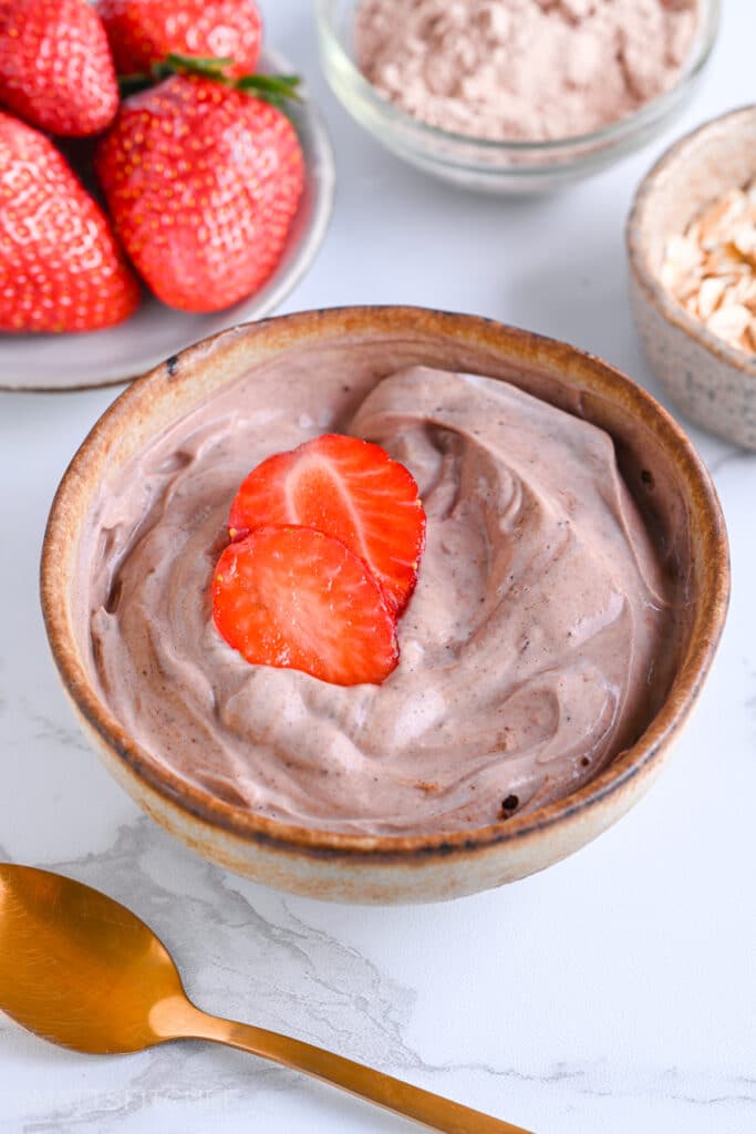 Greek yogurt and protein powder, smooth and creamy topped with vibrant strawberries