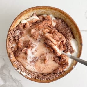 Adding milk to Greek yogurt and protein powder for a creamier texture