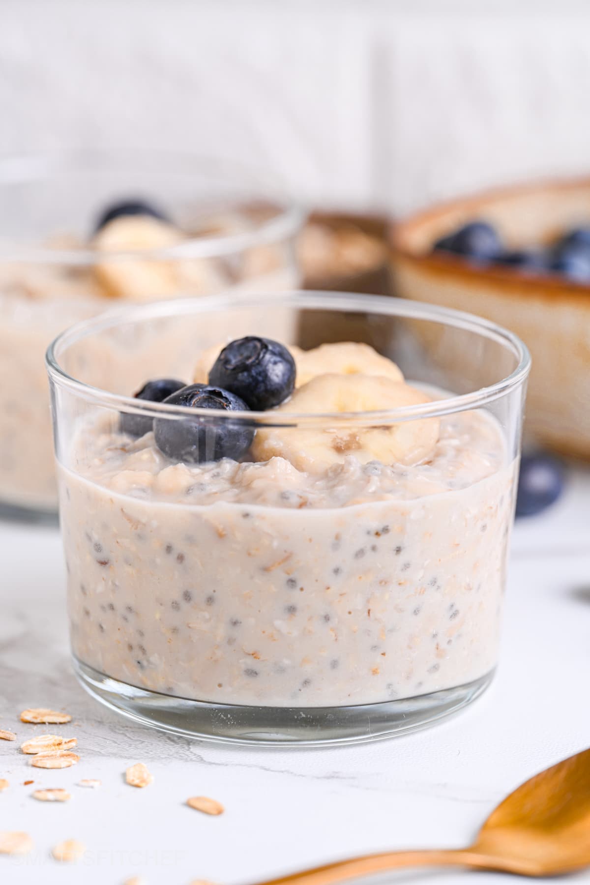 Meal prep overnight oats with protein powder, served with juicy blueberries and sliced banana