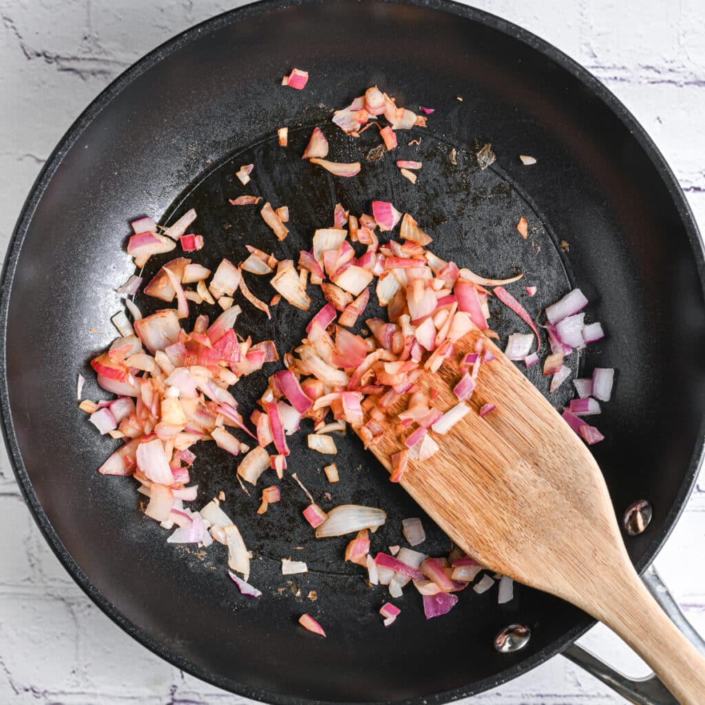 Saut&eacute;ing onion and garlic in a skillet before blending with cottage cheese