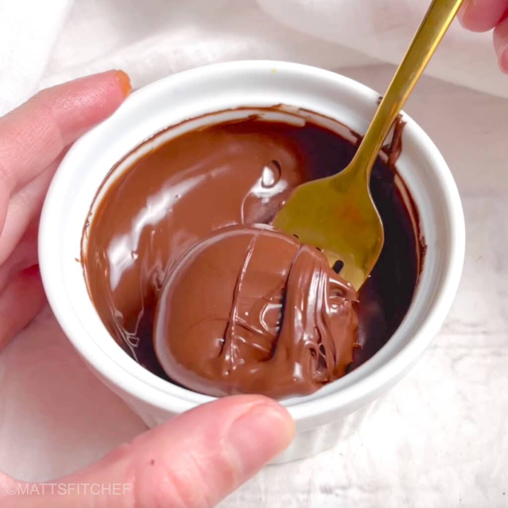 Dipping peanut butter banana bites in melted chocolate