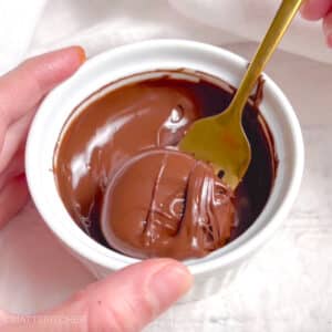 Dipping peanut butter banana bites in melted chocolate