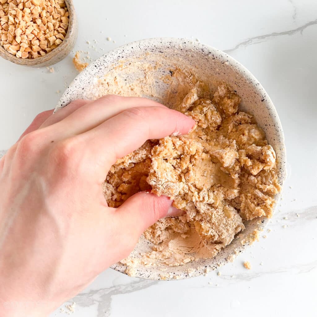 Kneading powdered peanut butter protein dough with help of hands