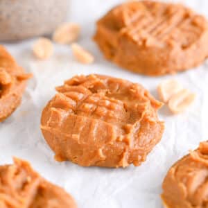 Front view of powdered peanut butter cookies, with peanuts in background