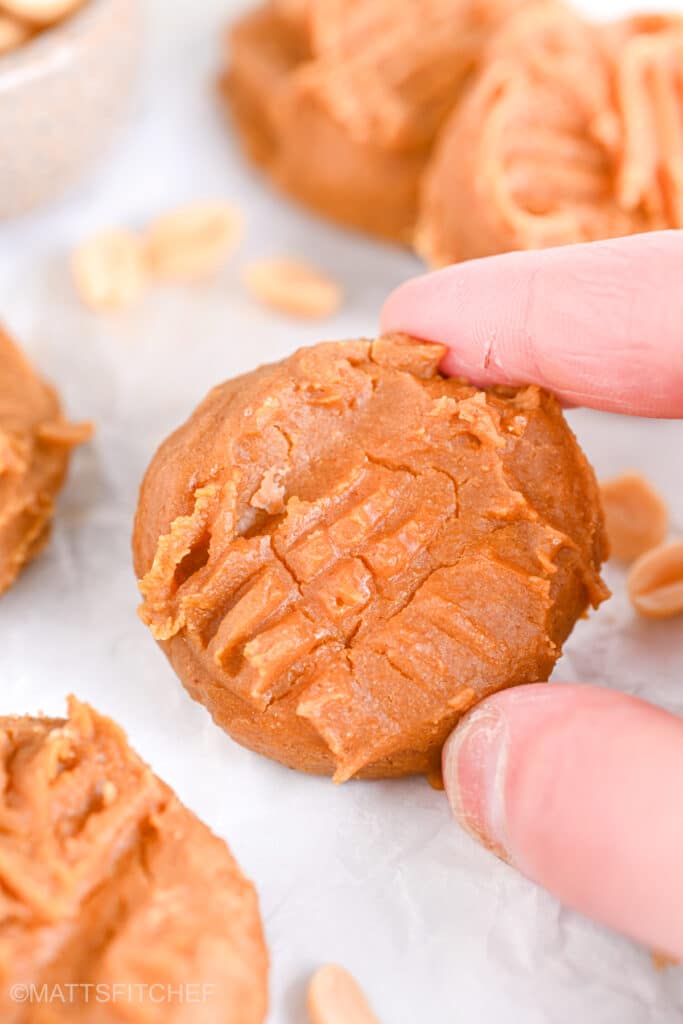 Low calorie high protein cookie with powdered peanut butter being hold between two fingers