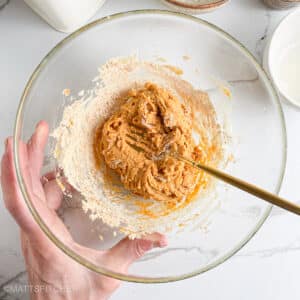 Smooth powdered peanut butter cookie dough in transparent bowl