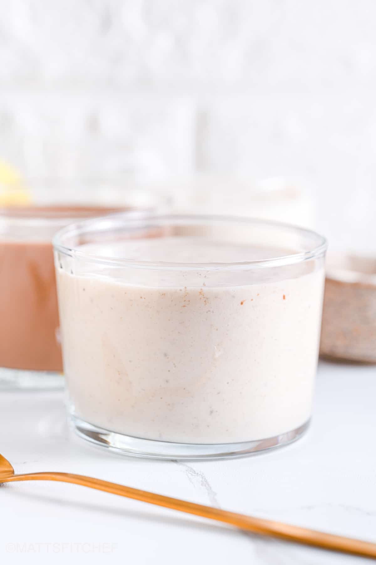 Front view of vanilla protein shake in transparent glasses