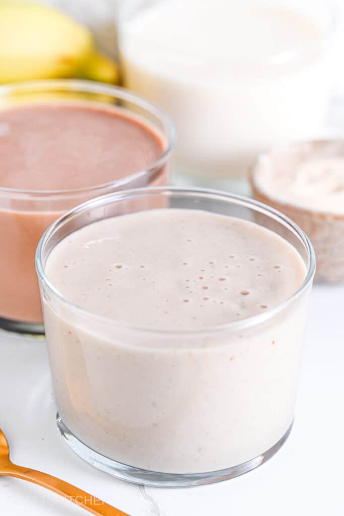 45&deg; angle view of vanilla and chocolate vanilla protein shake in glasses