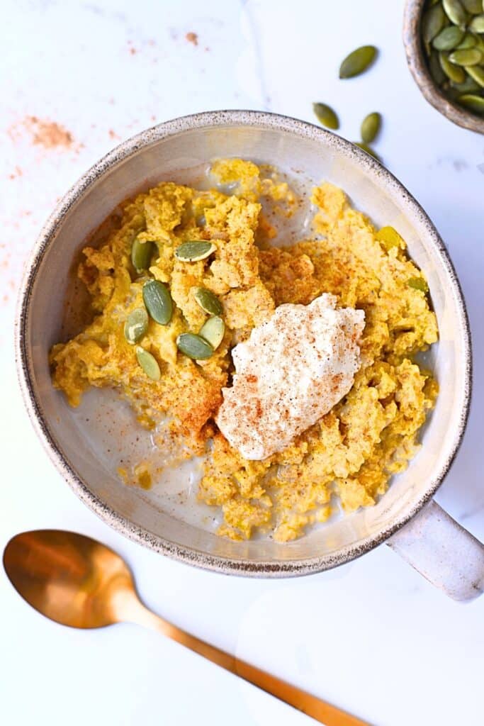 High protein pumpkin oatmeal with pumpkin seeds and cottage cheese as toppings